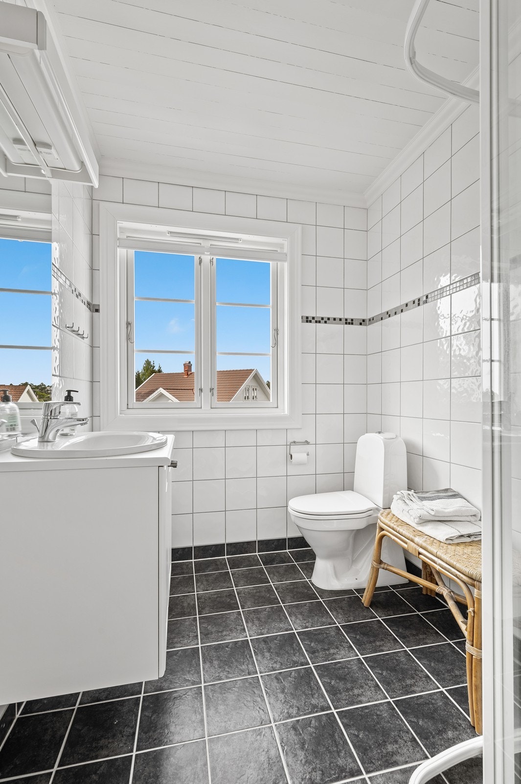 Badet i 2. etasje er flislagt med varmekabler i gulv og inneholder toalett, servant med underskap og dusjhjørne. Galleribilde