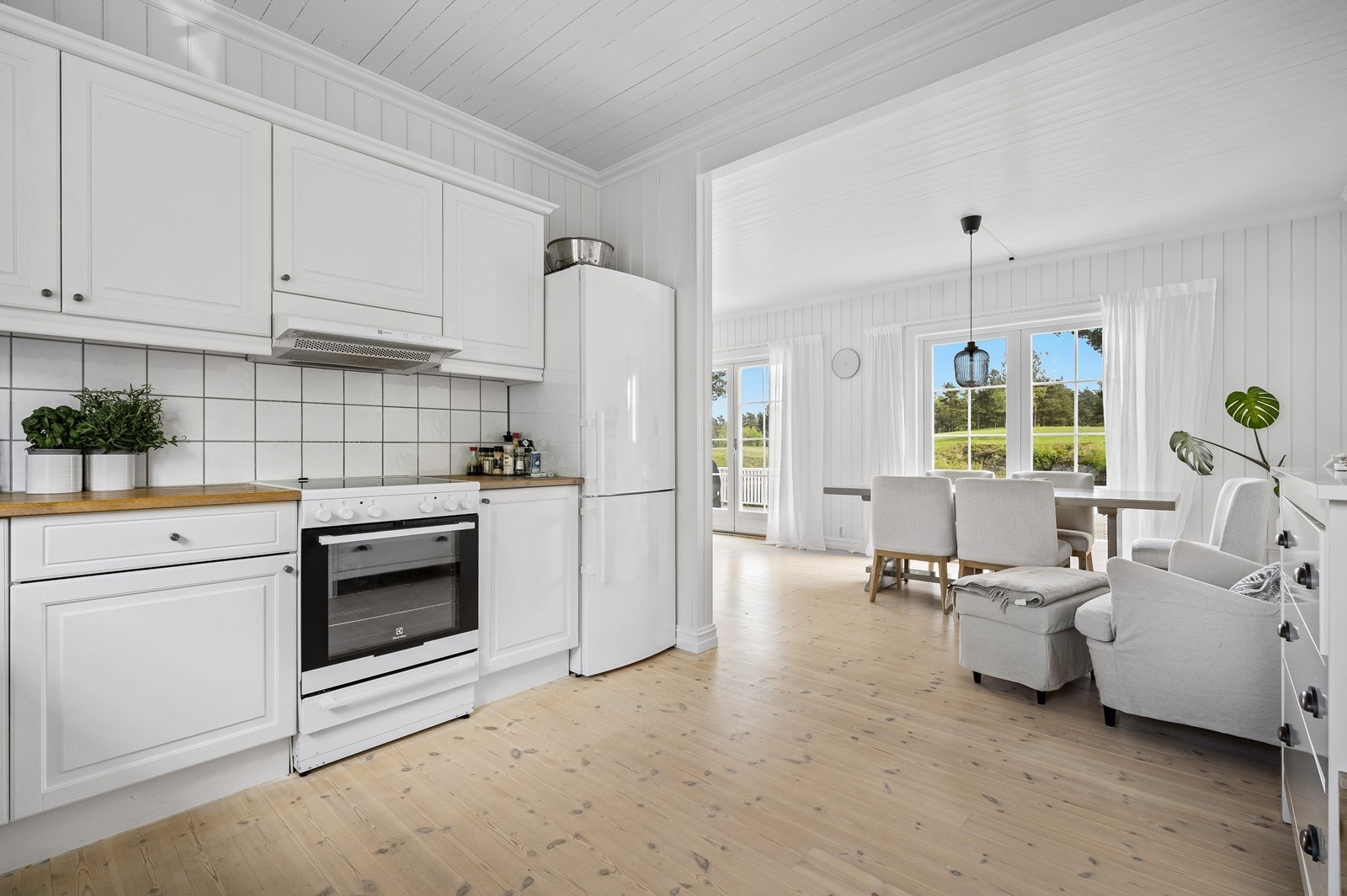 Kjøkkenet har en pen innredning med lyse, profilerte fronter, laminert benkeplate og frittstående hvitevarer. Galleribilde
