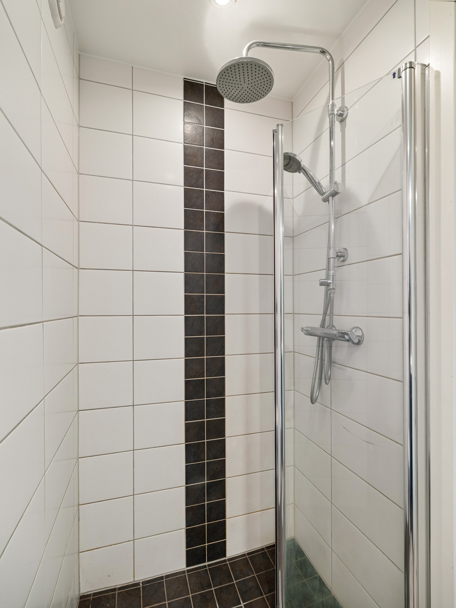 Utstyrt med toalett, servant med underskap og dusjnisje med innfellbare glassdører. Opplegg for vaskemaskin. Galleribilde