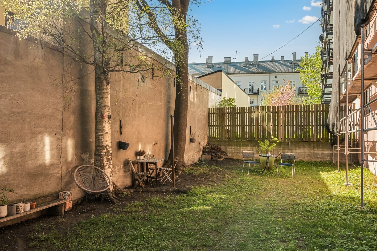 Midt mellom bygårdene åpner det seg en grønn og solfylt bakgård som virkelig skaper trivsel i hverdagen. Galleribilde