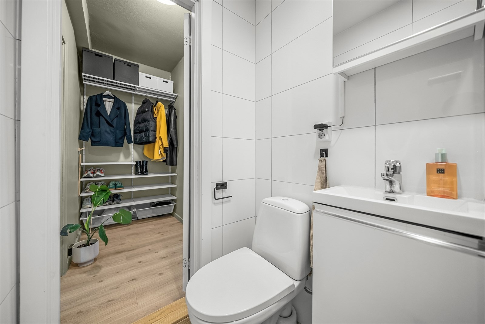 Baderomsinnredning med glatte, folierte fronter og heldekkende servant. Speilskap med lysarmatur, gulvmontert toalett og
dusjhjørne med skyvedør. Galleribilde