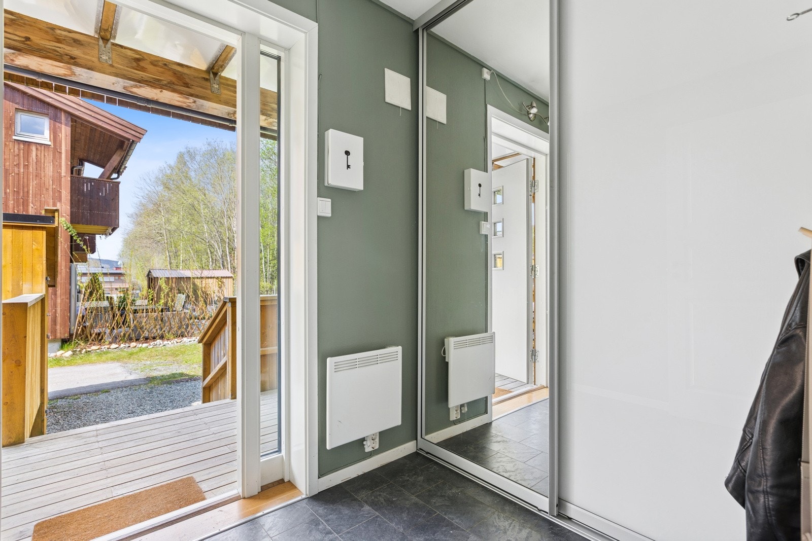 Lys og innbydende entrè med skyvedørsgarderobe Galleribilde