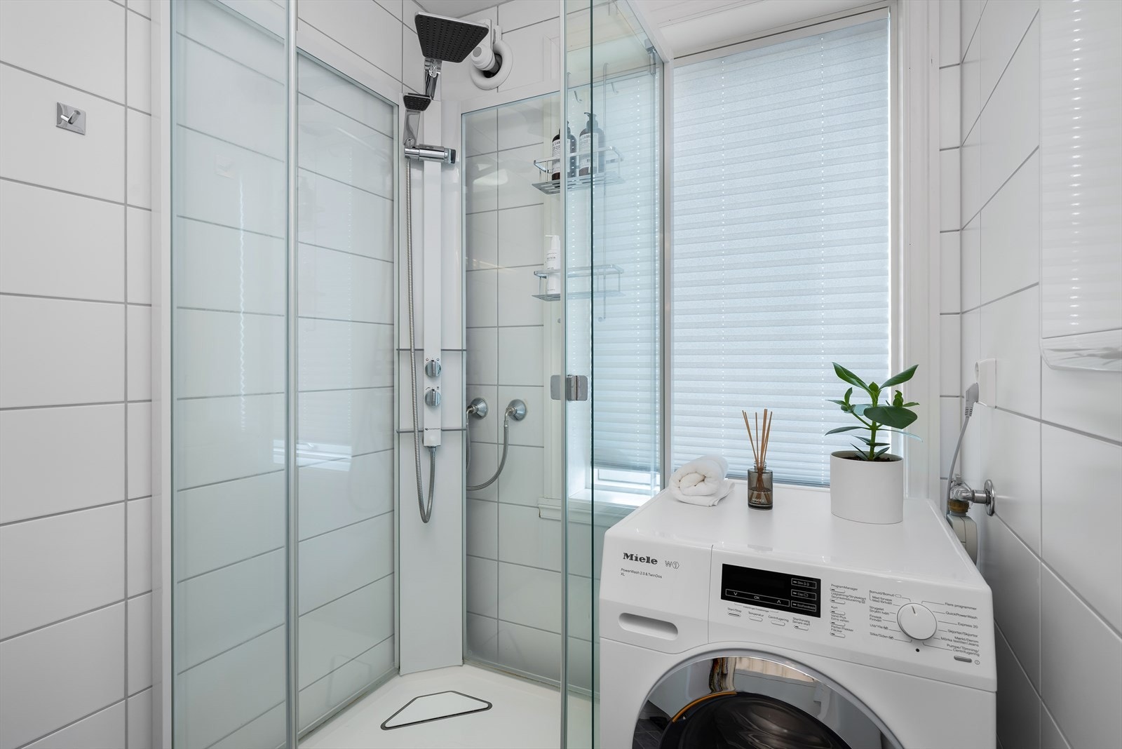 Komplett bad med dusjkabinett, nedfelt servant, toalett og praktisk tilkobling for vaskemaskin. Galleribilde