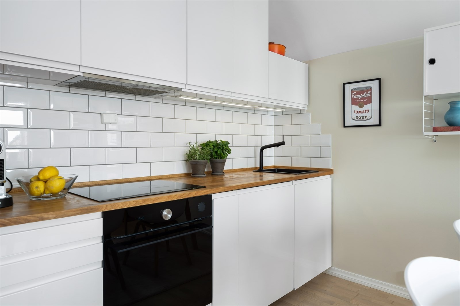 Kjøkkenet er utstyrt med benkeplate i heltre, induksjonstopp, oppvaskmaskin, stekeovn og komfyrvakt | En gjennomført løsning som kombinerer kvalitet og funksjonalitet. Galleribilde