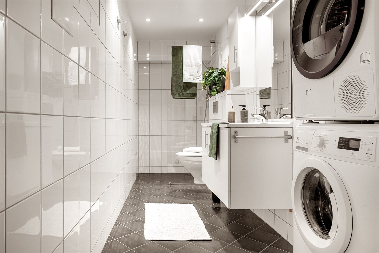 Badet ble pusset opp i 2008 og inneholder vegghengt toalett, helstøpt servant, skap under servant med slette fronter, dusjvegg i klart glass, opplegg for vaskemaskin og fordelerskap til rørsystemet Galleribilde