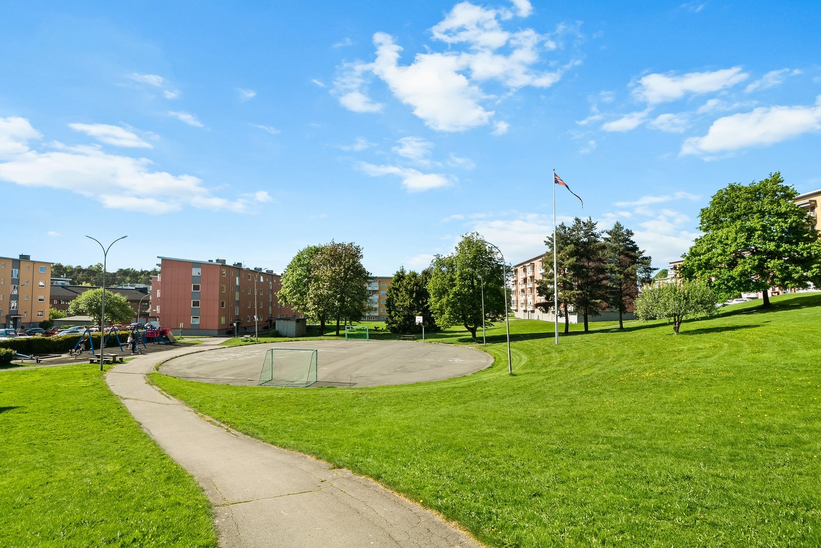 Nedenfor boligblokken er det fine lekeplasser, fotballbane og sitteplasser. Meget barnevennlig og helt uten biltrafikk. Galleribilde