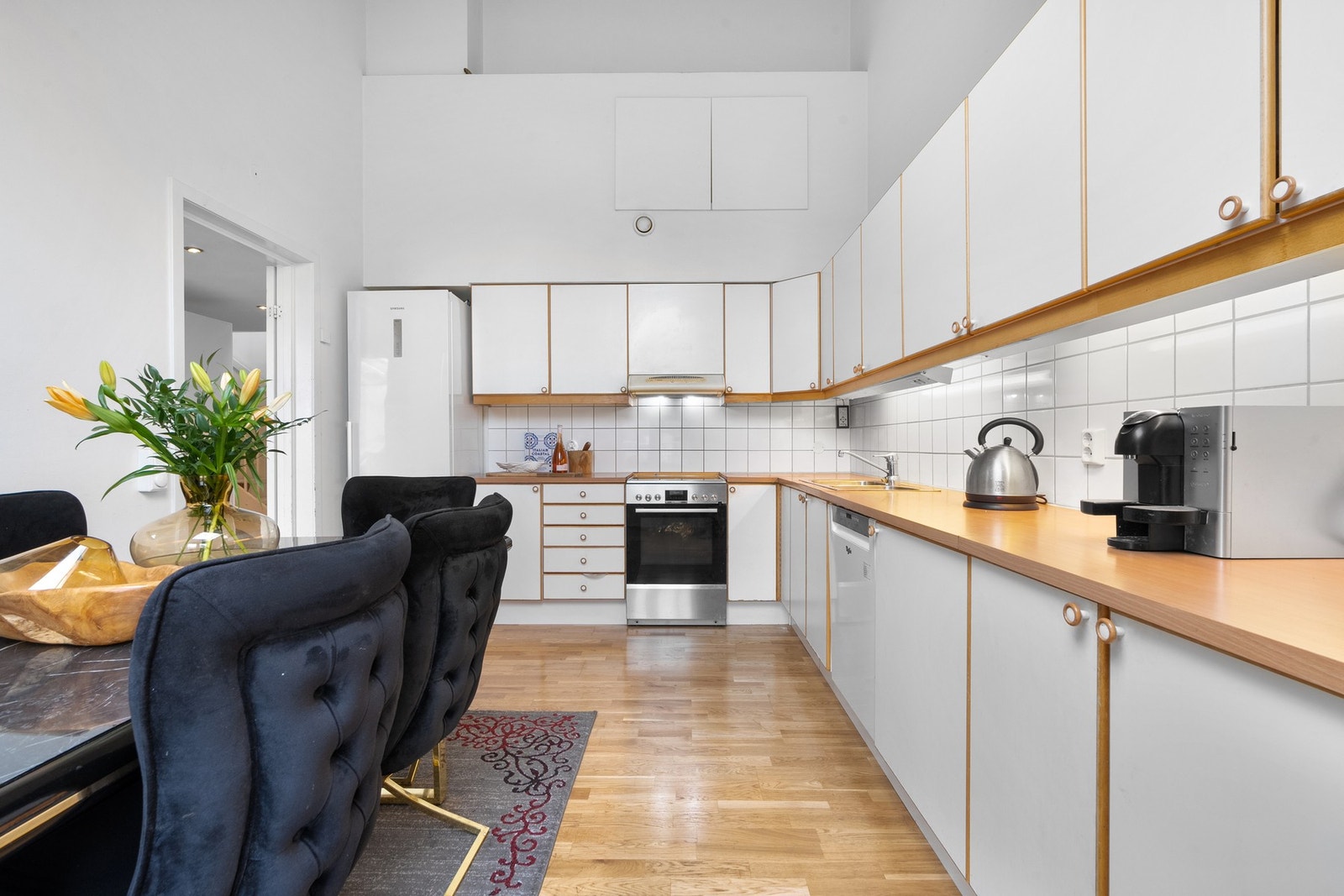 Det er eldre kjøkkeninnredning med glatte, foilerte fronter med heltre rammer levert fra Norema. Galleribilde