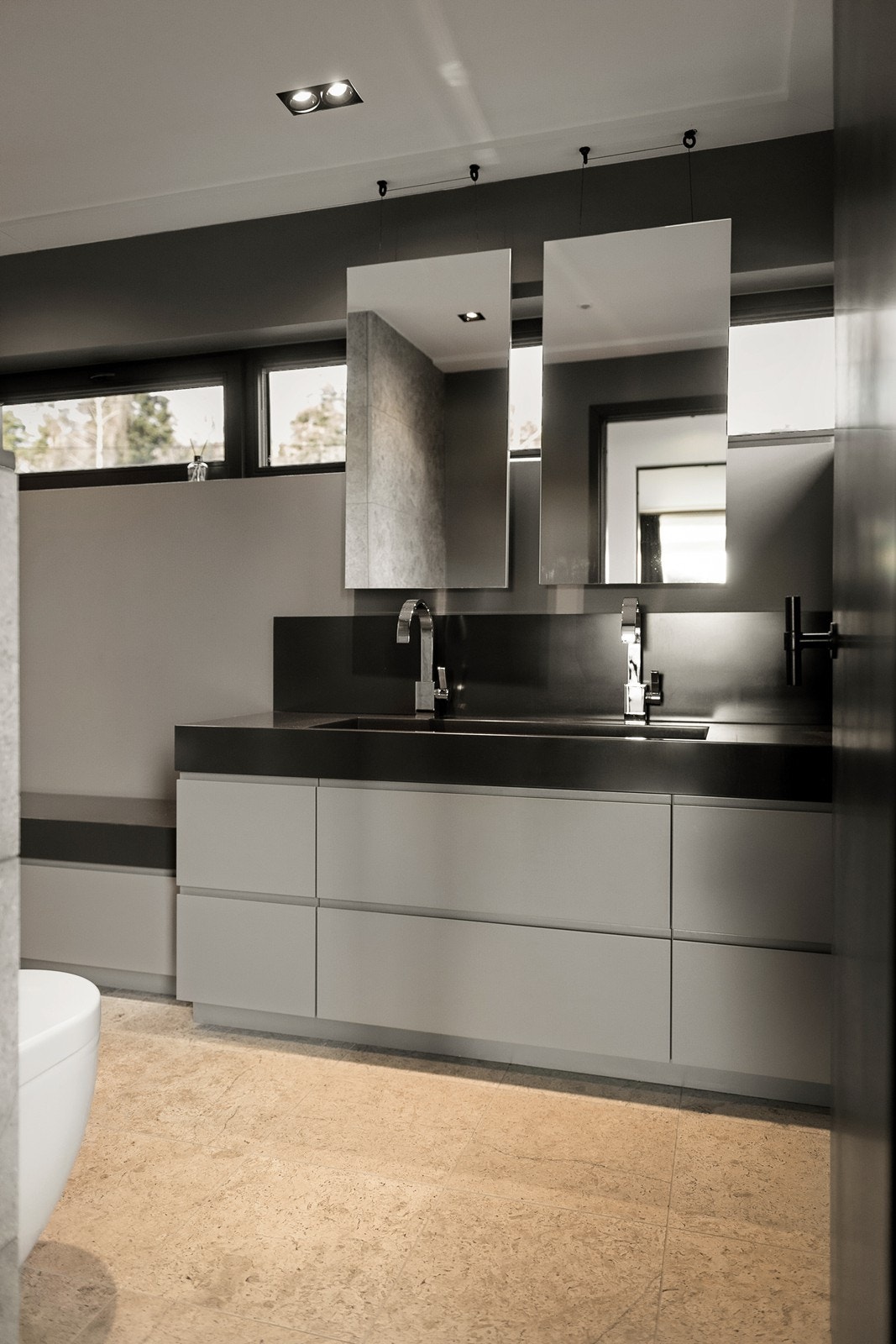 servant med underskap og speil med naturlig belysning fra vinduene bak. Galleribilde