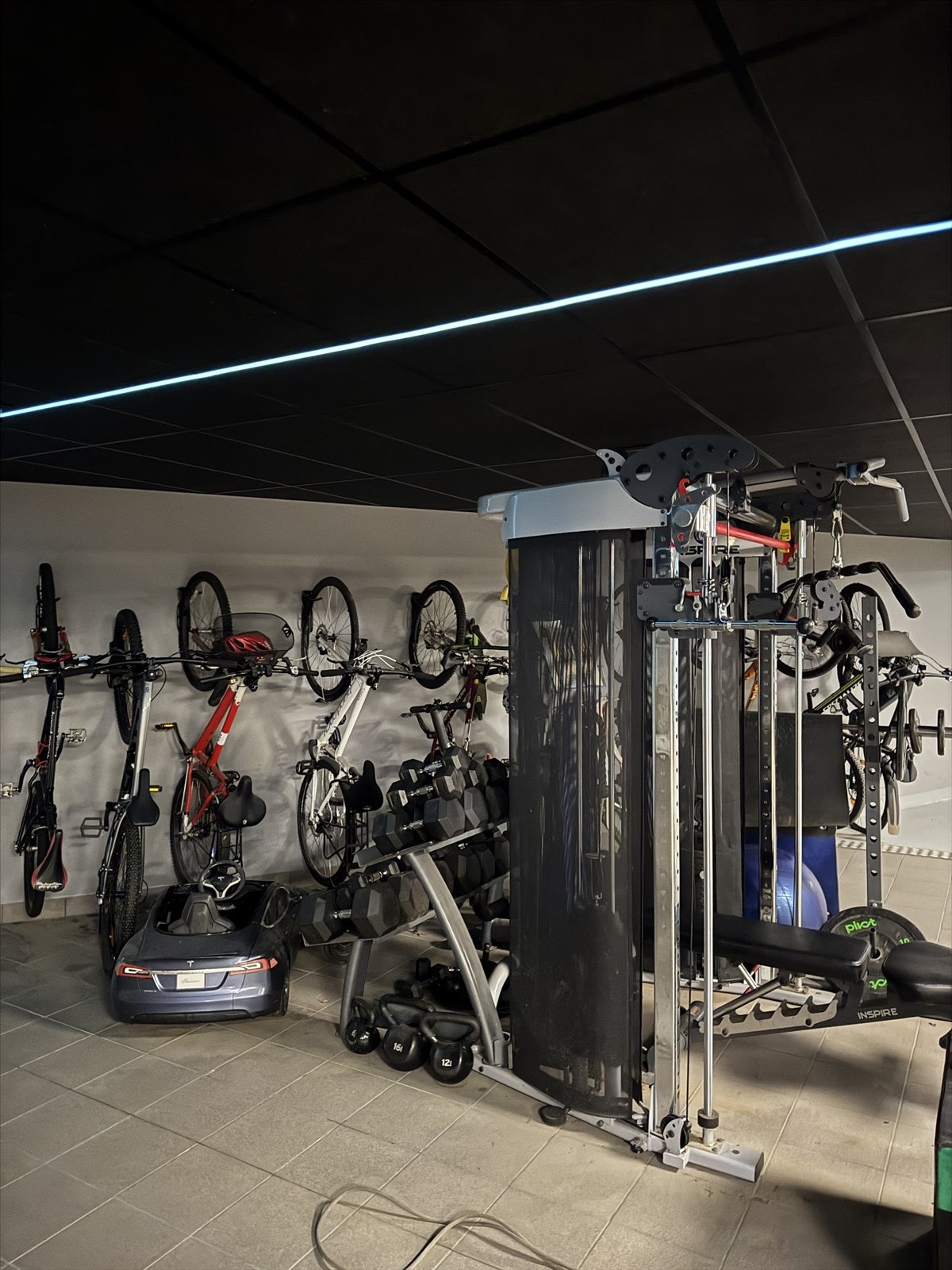Trenings sone i garasjen med treningsapparater og utstyr, vegghengt sykkelparkering Galleribilde