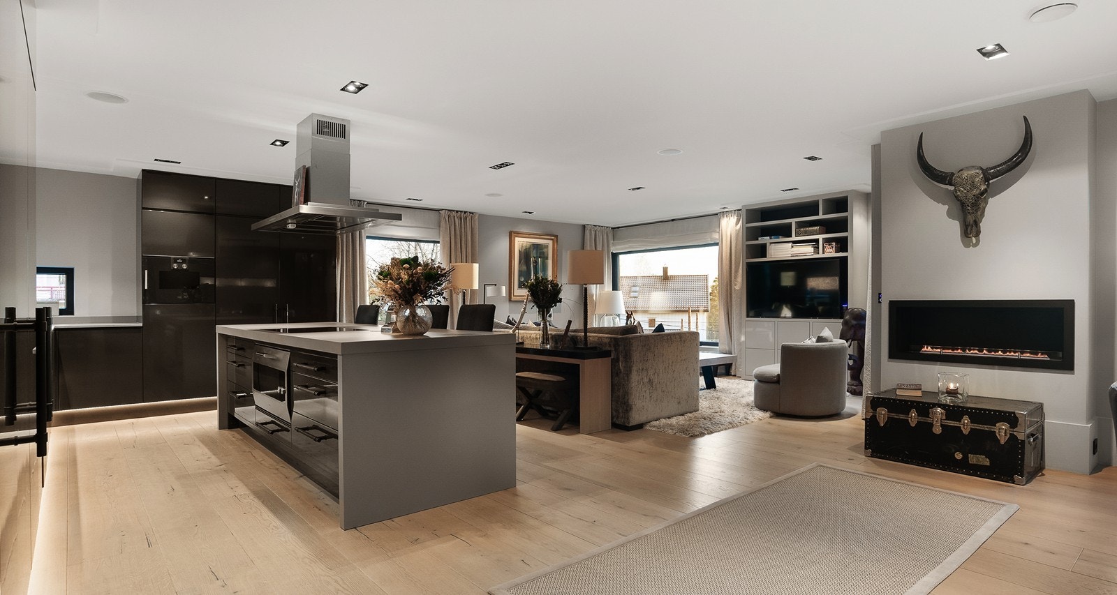 Åpen stue kjøkkenløsning, peisen er et blikkfang med en gang man går inn i rommet. Galleribilde