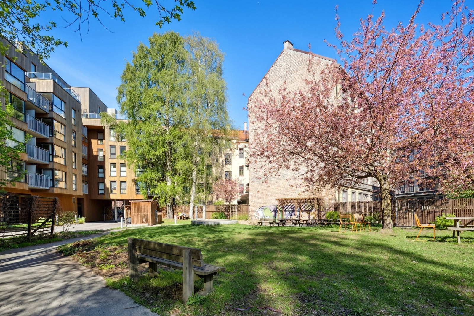 Pent opparbeidet bakgård med flere sitteområder og griller – et hyggelig sted for både avslapning og sosiale samlinger. Galleribilde