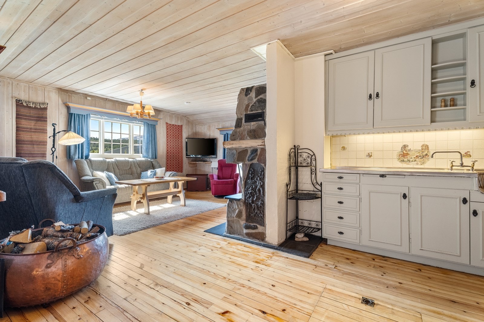 Hytta har en åpen stue/kjøkkenløsning Galleribilde