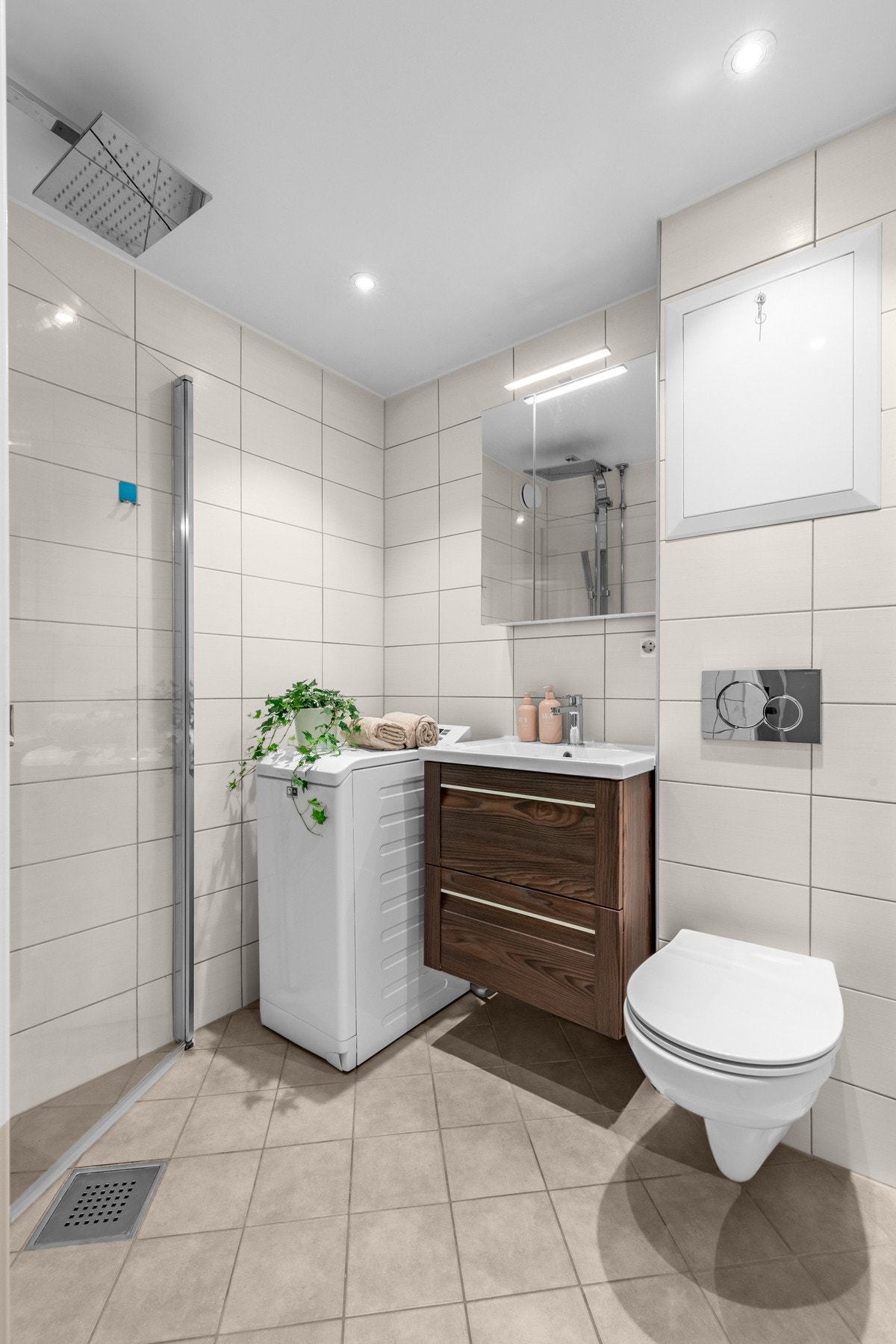 Et lyst og fint bad med termostatstyrte varmekabler og dusjhjørne med svingdører. Galleribilde