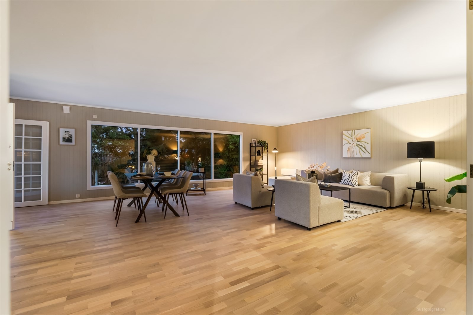 Stuen har panoramavinduer mot hagen Galleribilde