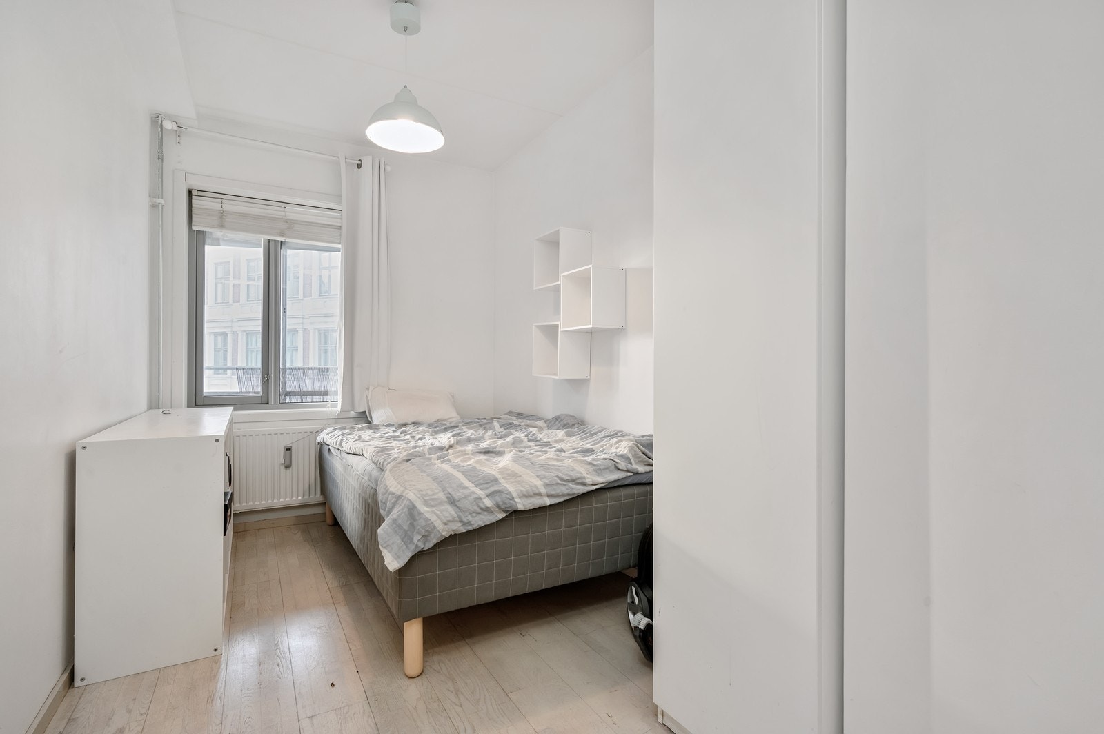 Soverom med garderobeskap, kommode og seng. Galleribilde