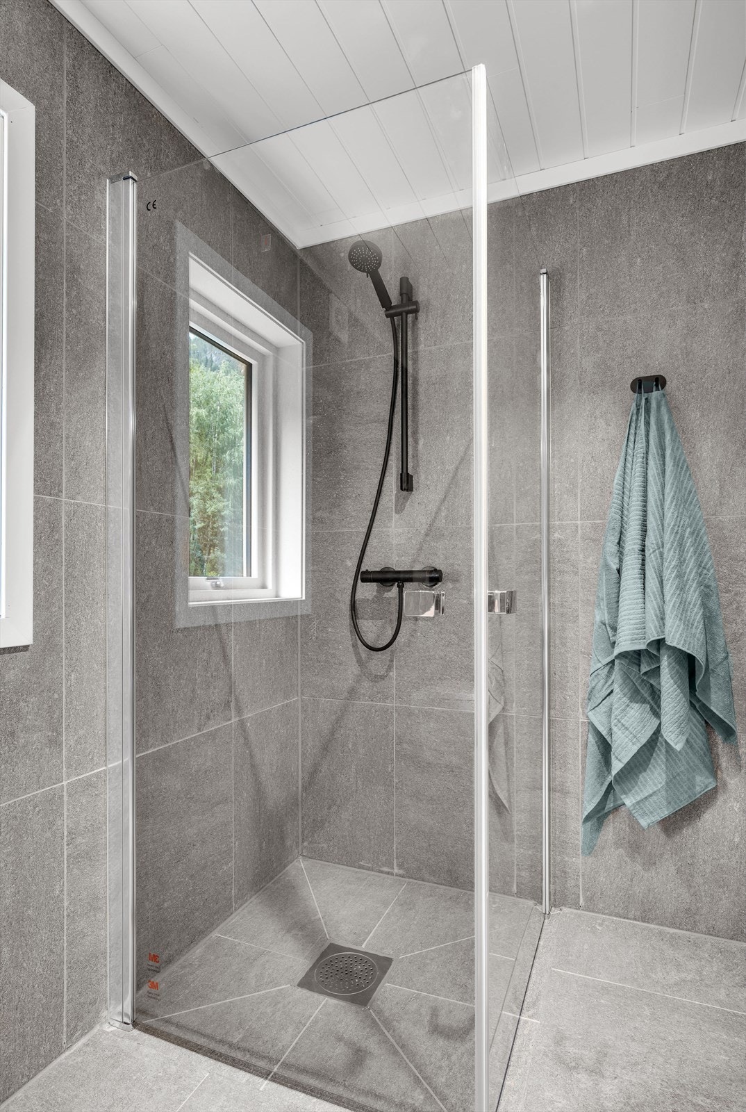 Badet har toalett, servantinnredning, dusjhjørne og opplegg for vaskemaskin Galleribilde