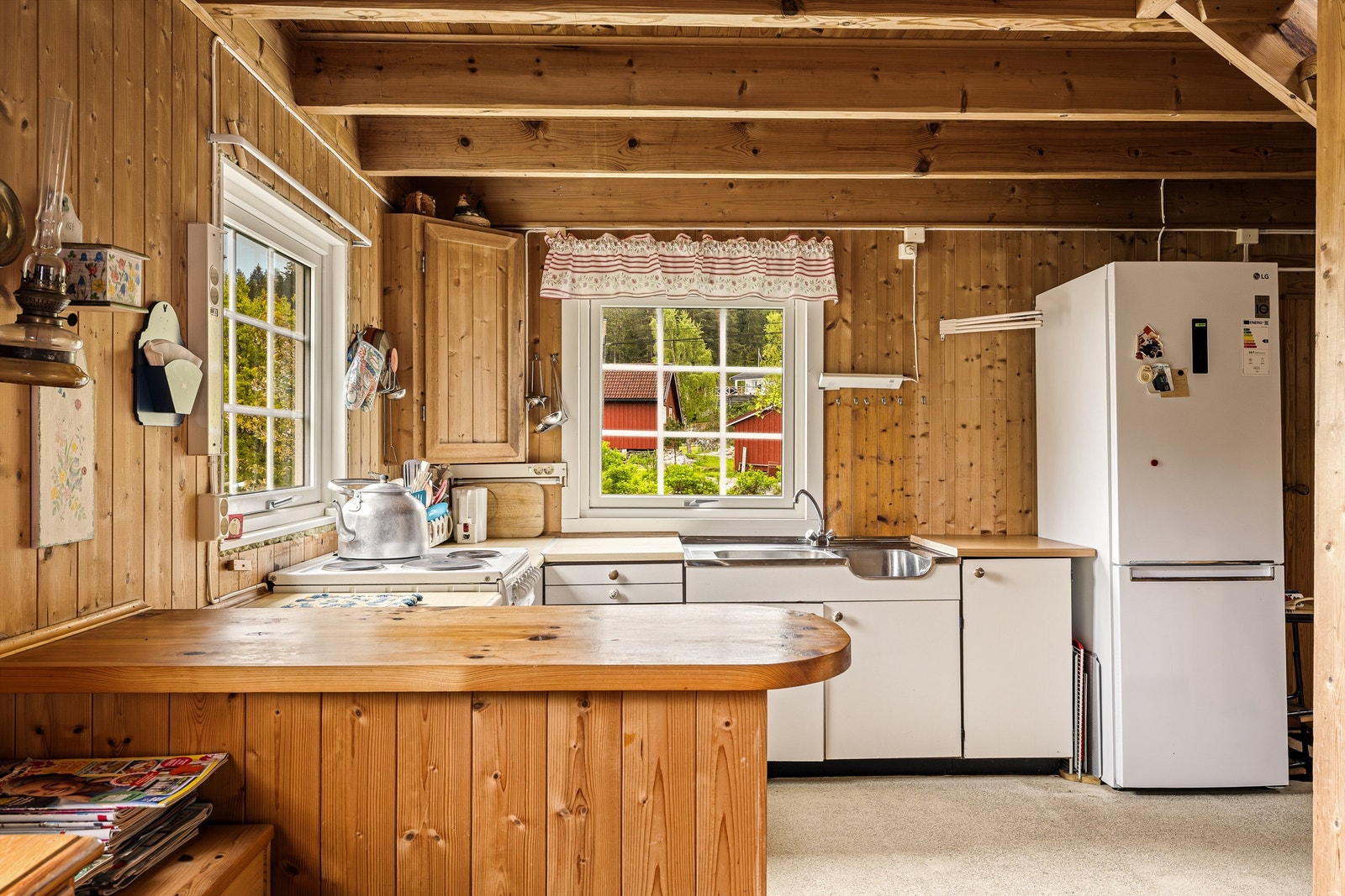 LANDLIG: Enkel kjøkkeninnredning med en benk som skaper skille mot stua. Galleribilde