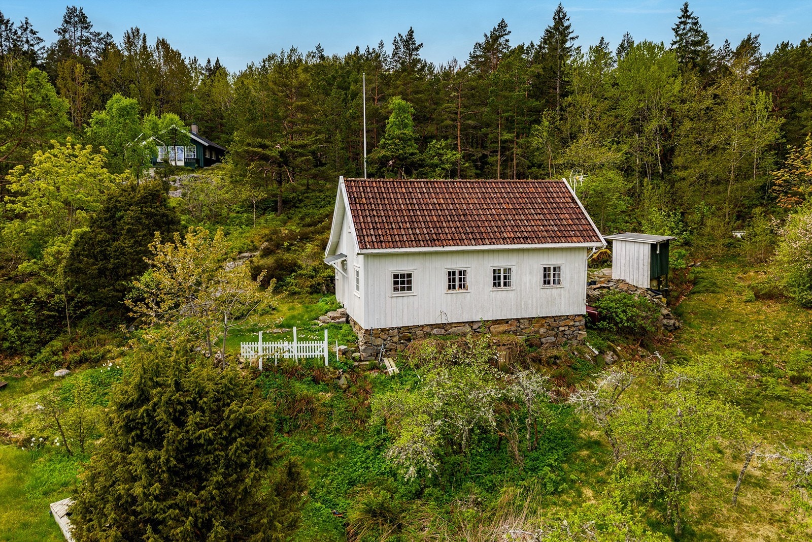 I en frodig skråing rett opp for Arøybukta, skrår en gammel nyttehage ned mot en åpen slette som tidligere var dyrket mark. Herfra fører en sti ned til bukta og sjøen hvor det er sjøbod og egen brygge. Galleribilde