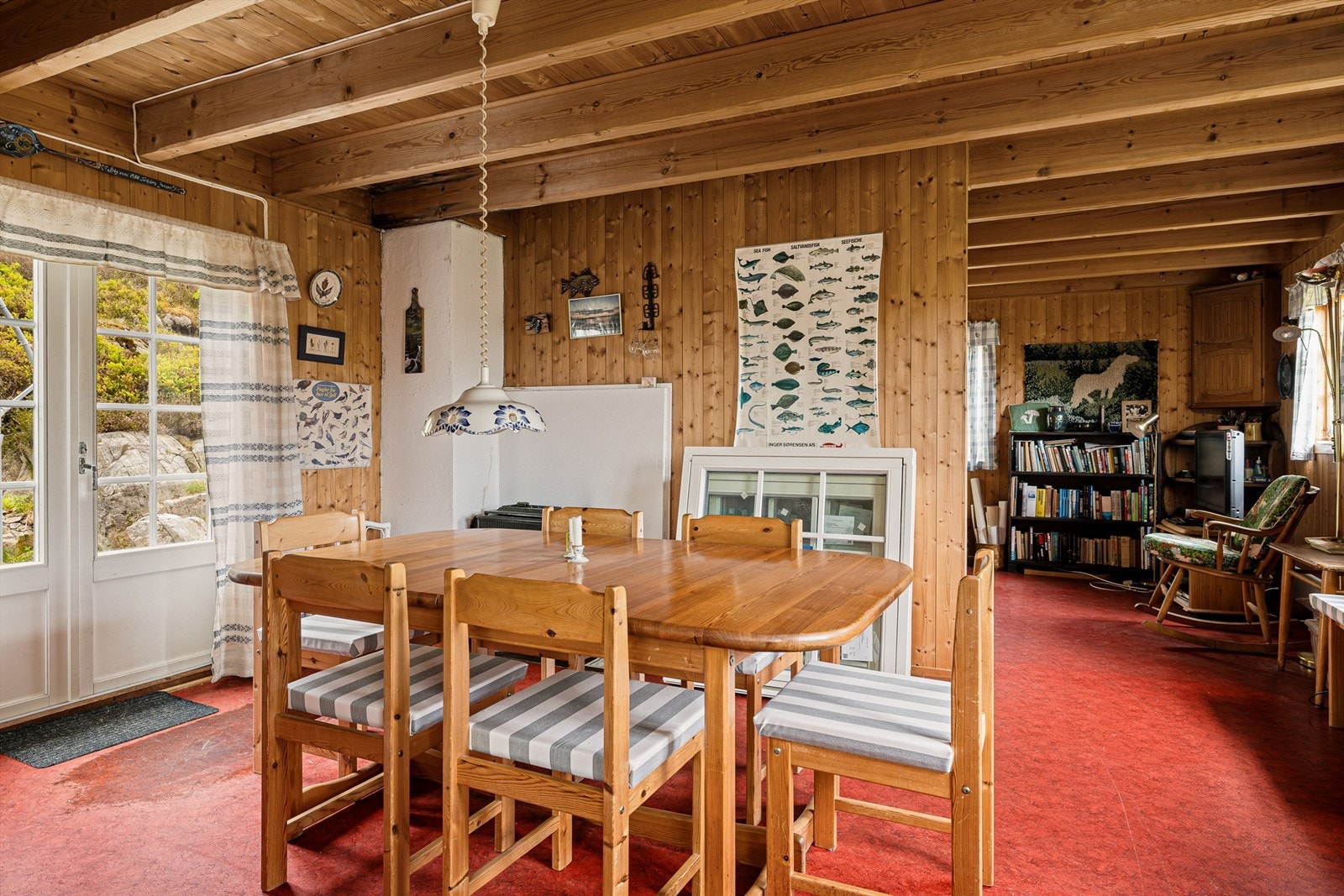 Fra spisestua er det utgang til uteplassen bak hytta. I hjørnet bak spisebordet er det en liten vedovn. Galleribilde