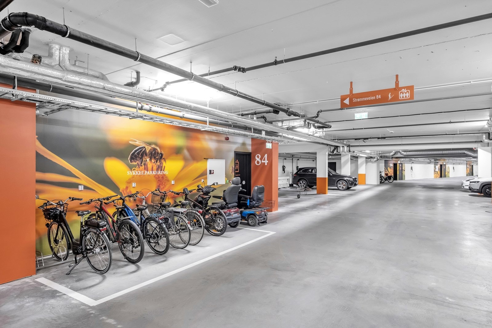 Underjordisk parkeringsanlegg med sykkelparkering, biloppstillingsplasser og lademuligheter for elektriske kjøretøy. Galleribilde