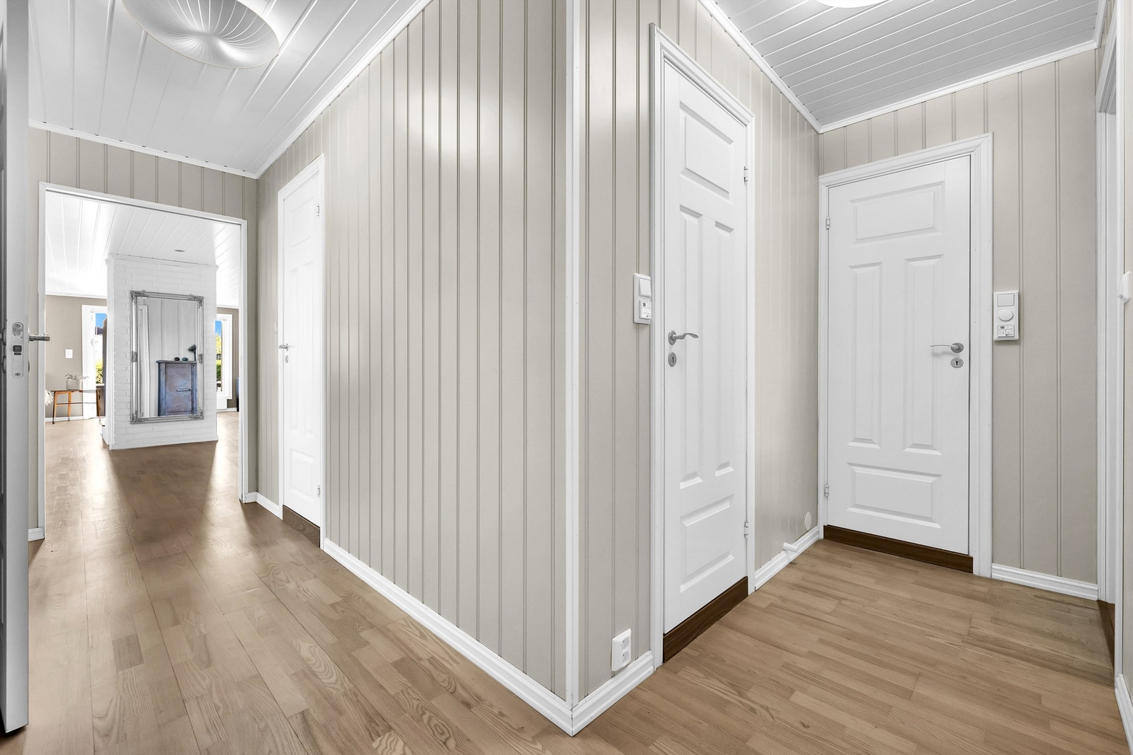 Lys gang med panel og parkett - praktisk planløsning og god flyt mellom rommene Galleribilde