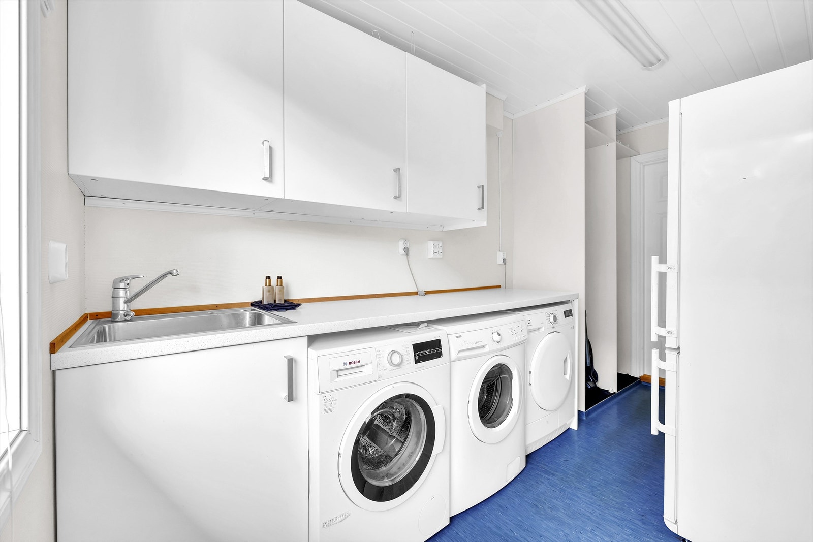 Romslig vaskerom med god plass til både vaskemaskin, tørketrommel og god oppbevaringsplass Galleribilde