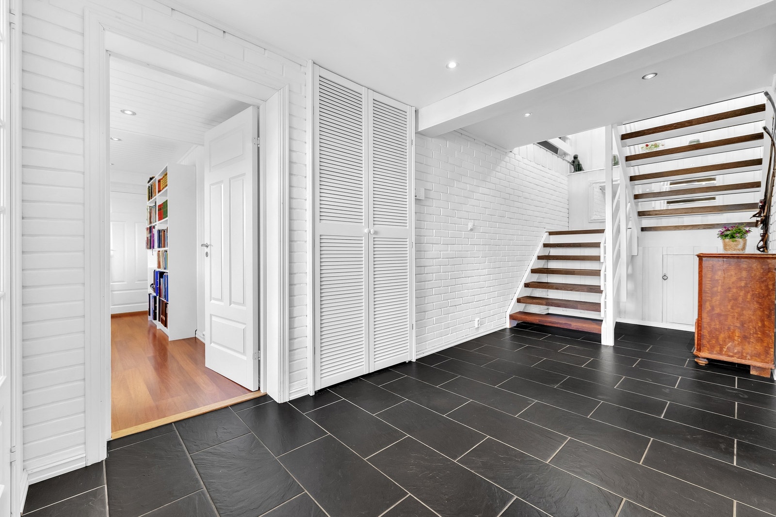 Lys og trivelig gang i underetasjen med flislagt gulv og god plass til oppbevaring og tilkomst til flere rom Galleribilde