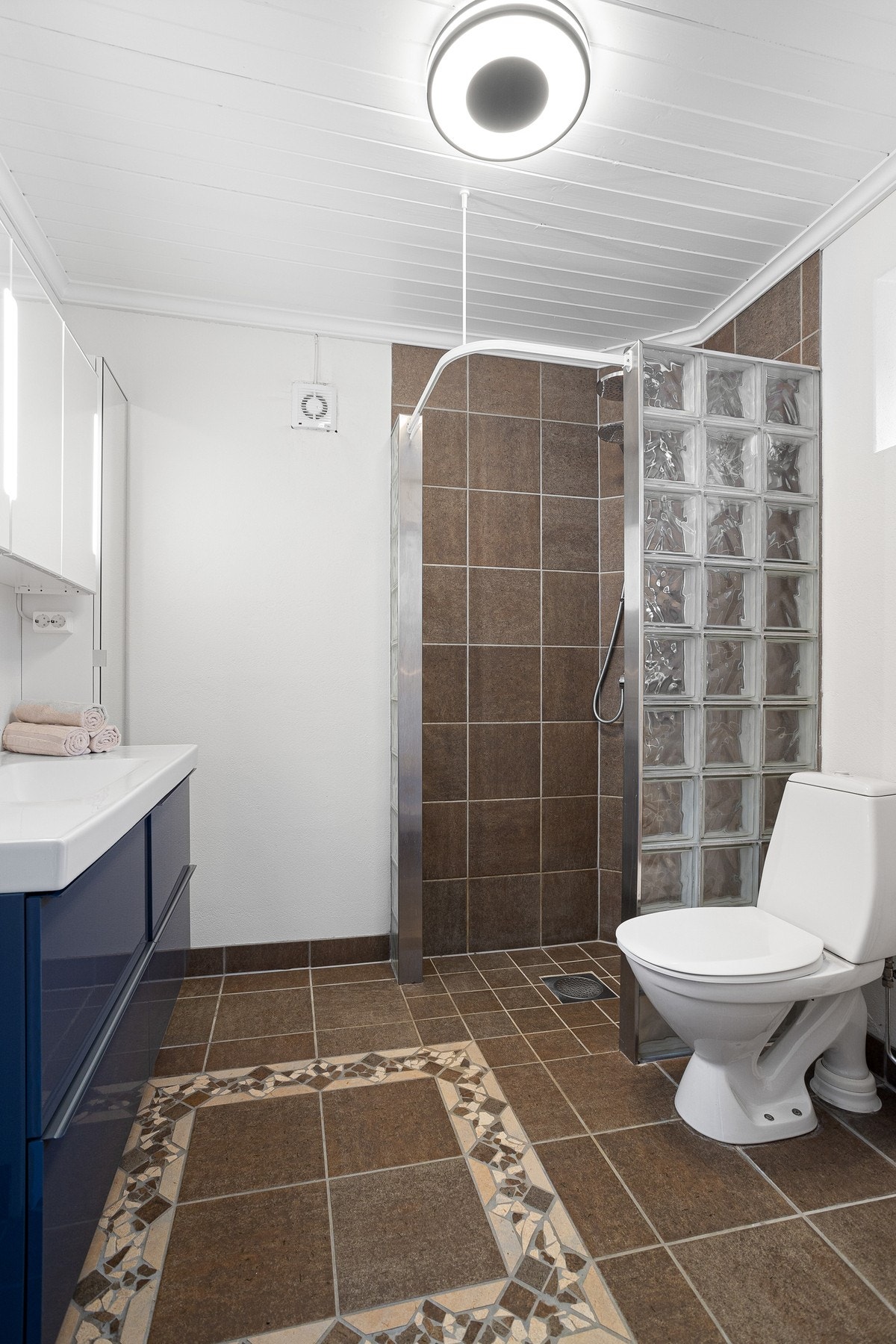 Hybel - Baderom med toalett, dusjhjørne og innredning med servant Galleribilde