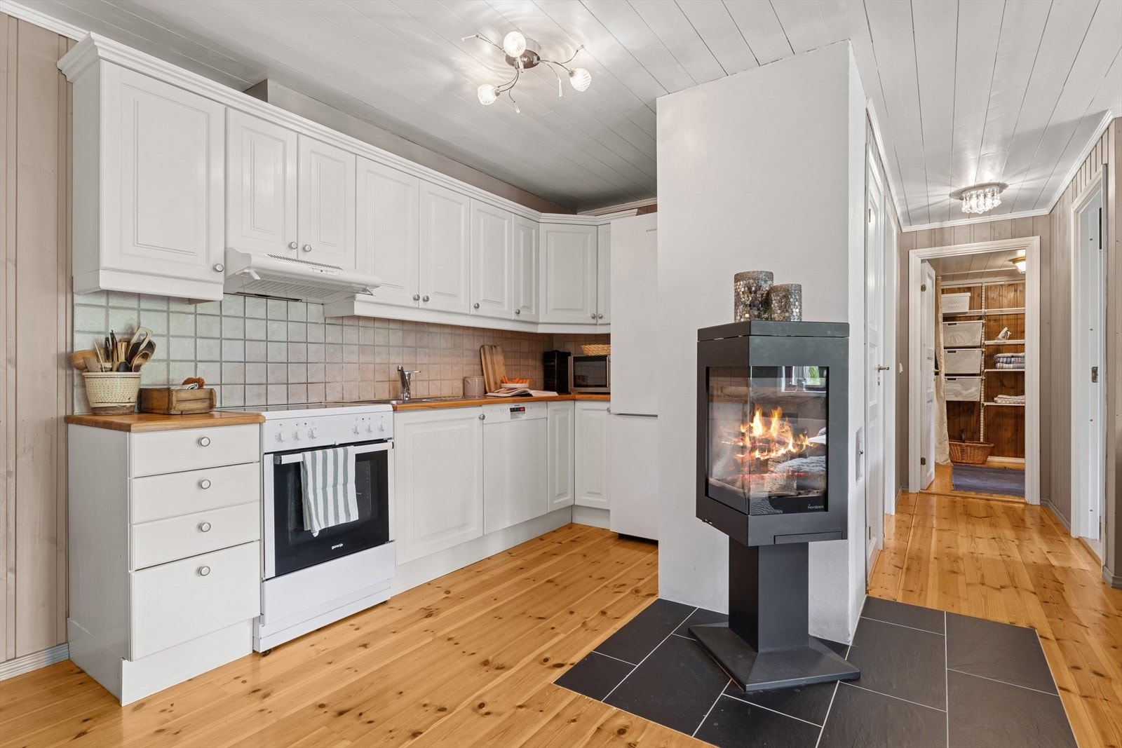 Sentralt plassert bidrar den moderne peisen til hygge og varme på de kjølige dagene. Galleribilde