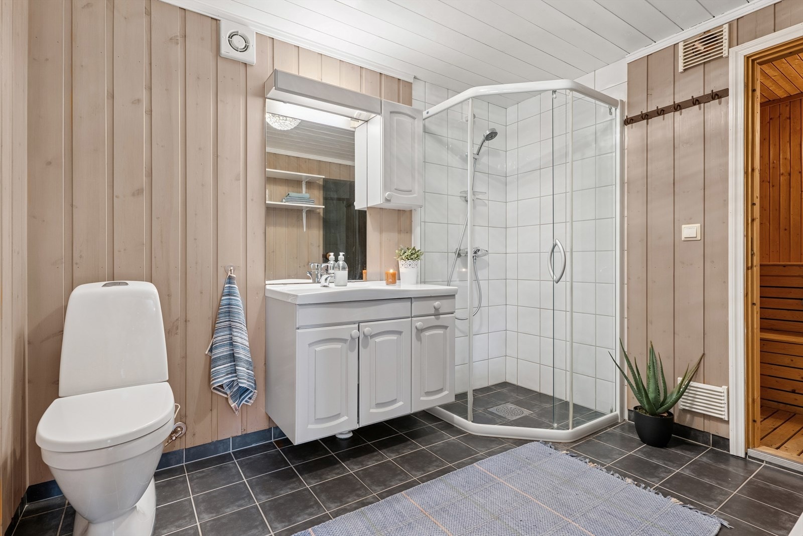 Det andre badet er av eldre dato og har flislagt gulv med behagelige varmekabler, panel på veggene, samt fliser på vegg i dusjsonen. Galleribilde