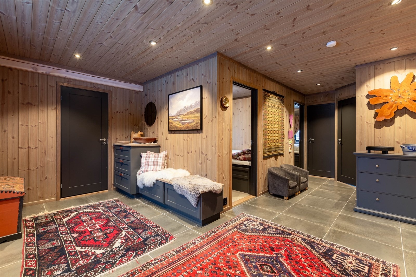 Stor flislagt hall med skigarderobe i hovedhytta. Galleribilde