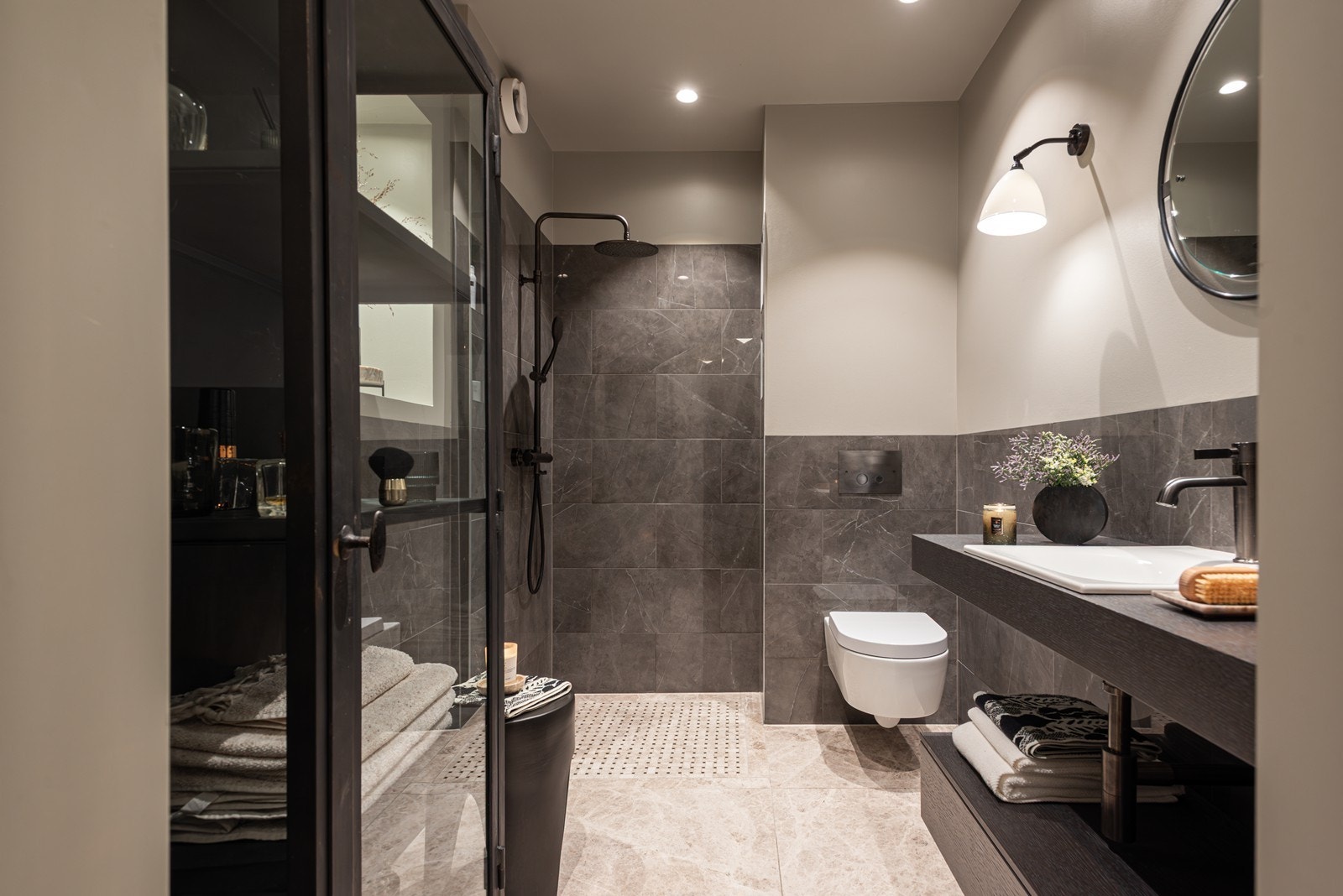 Eksklusivt hovedbad med kalksten på gulv og marmorerte fliser på vegg fra Fire Earth Galleribilde