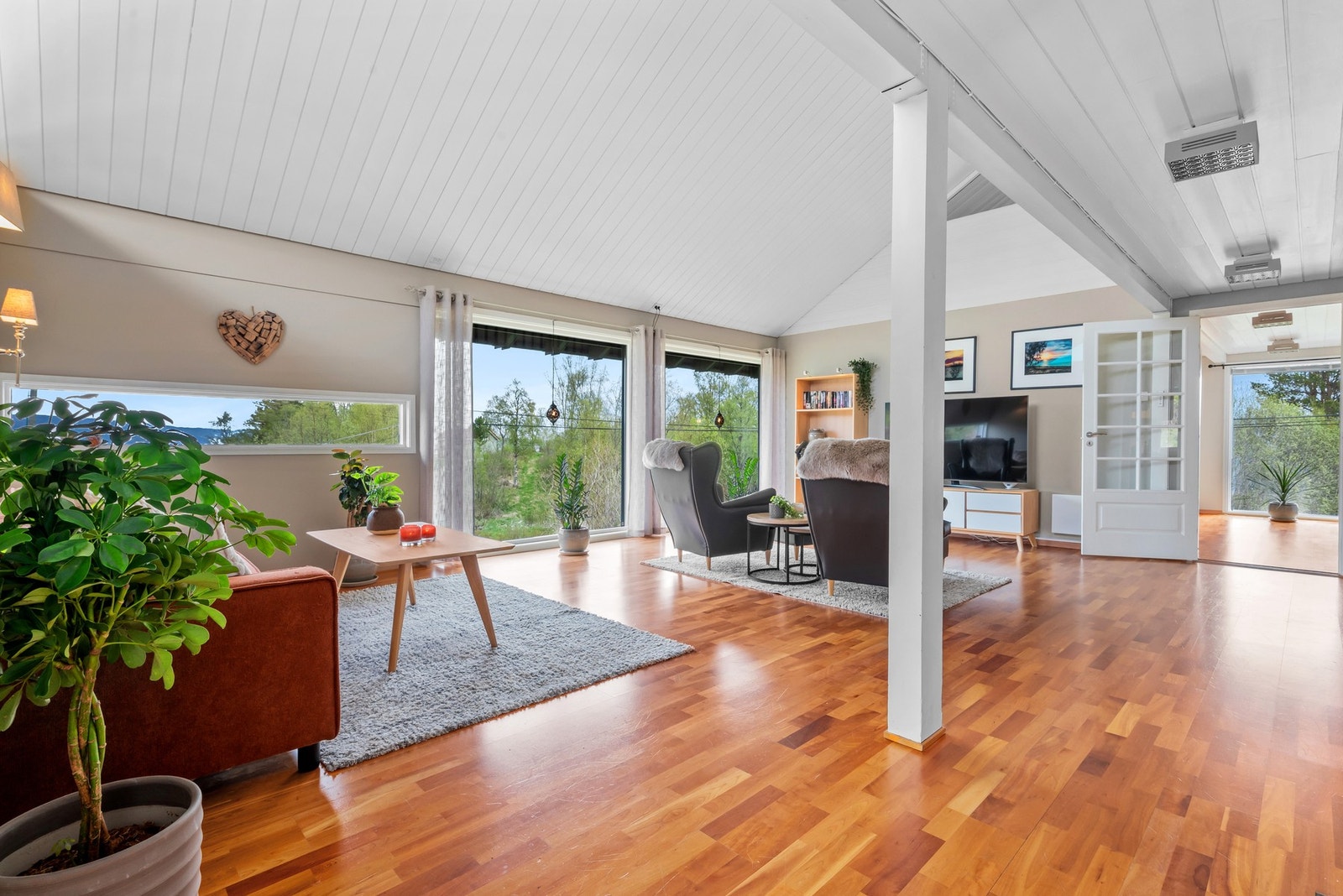 Store vinduer i tre retninger sørger for gode lys- og utsiktsforhold i stuen. Galleribilde