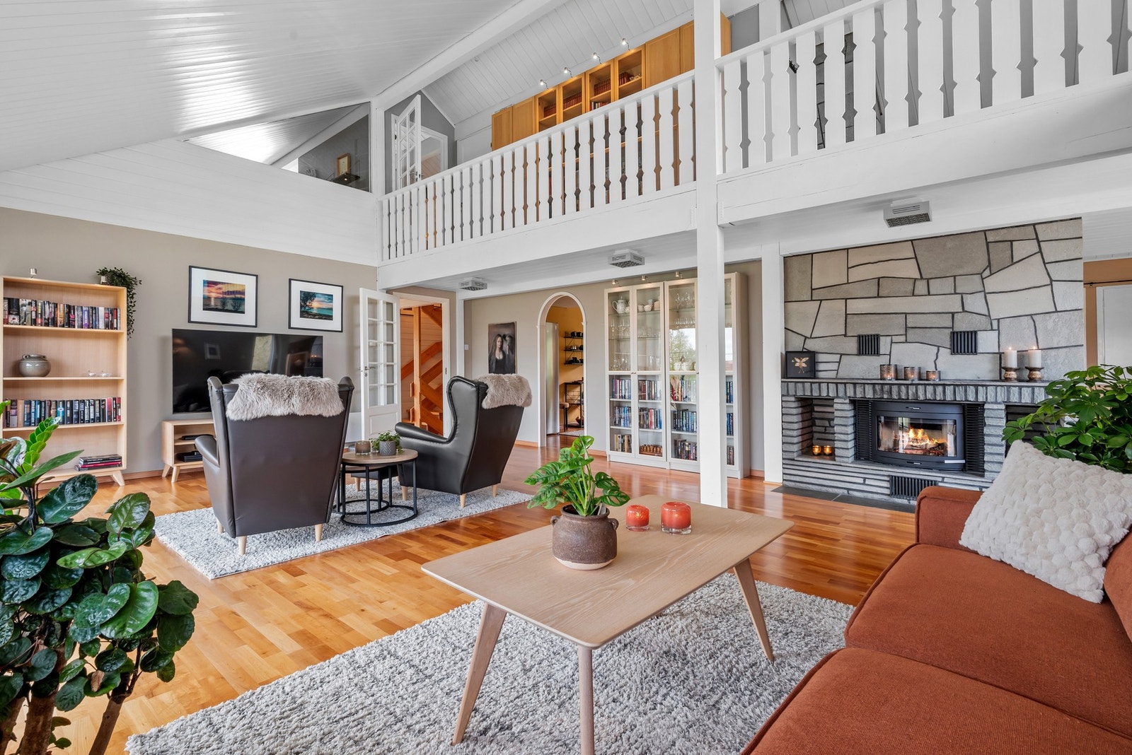 En stor peis fungerer som romdeler, og med både varmepumpe og to ildsteder får man det lunt og godt i stuen. Galleribilde