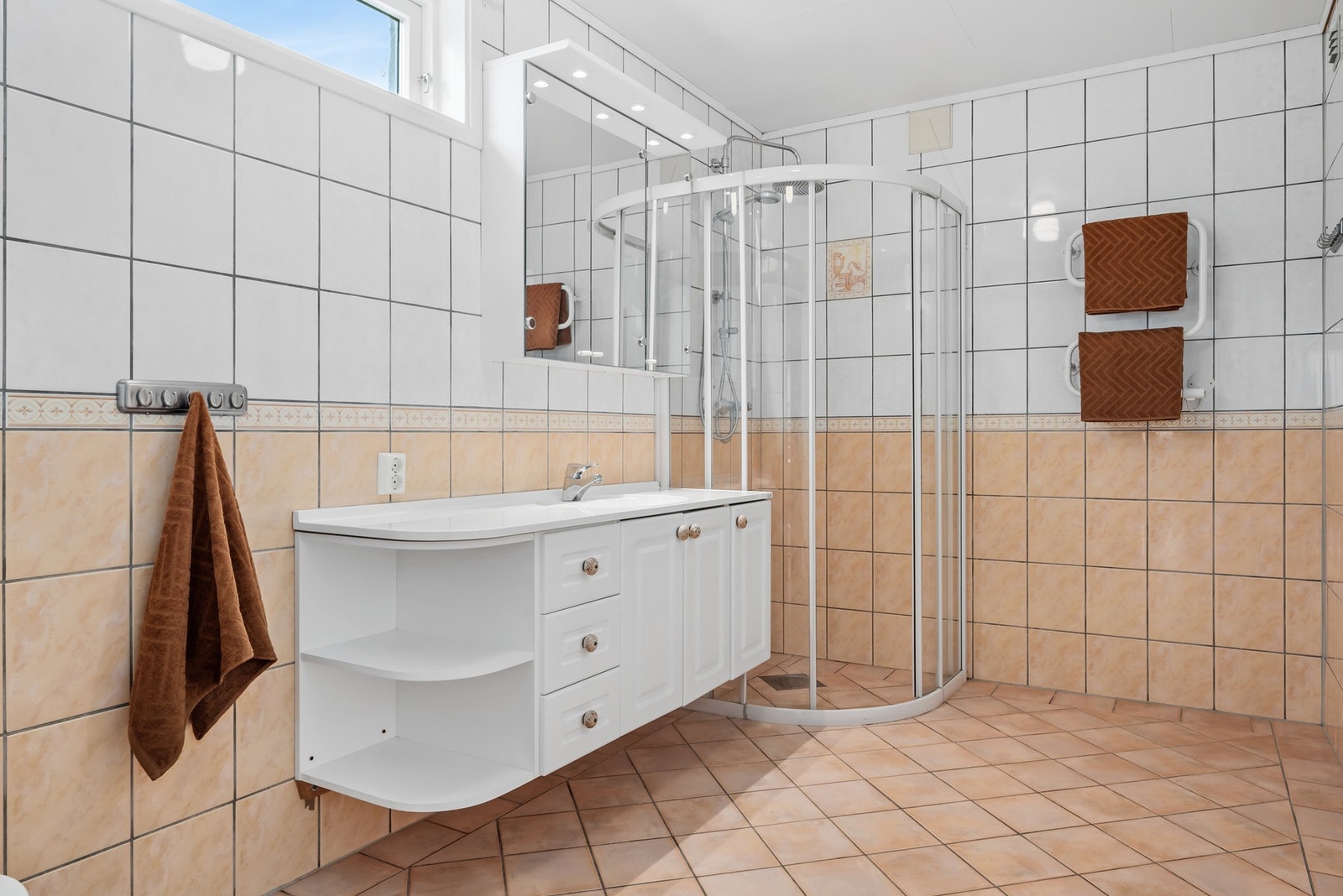 Badet i underetasjen har god størrelse, innredet med fliser, gulvvarme og regnfallsdusj. Galleribilde