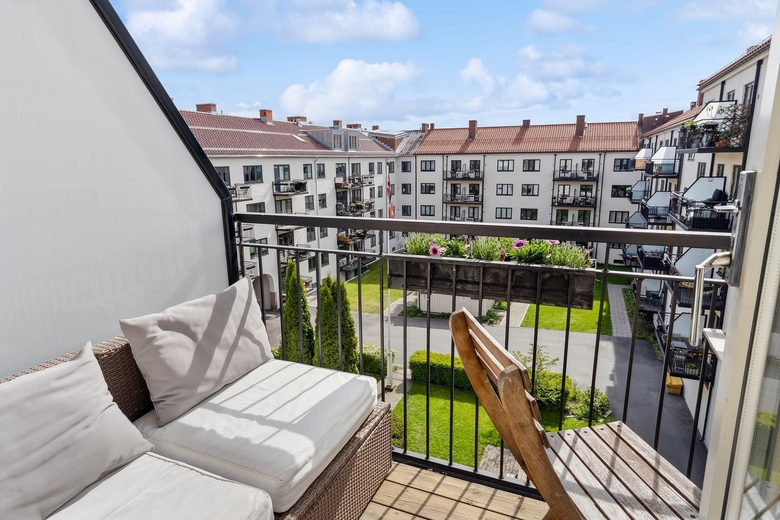 Solrik og møblert balkong med sittegruppe – et fredelig uterom med utsyn mot rolige fellesområder. Galleribilde