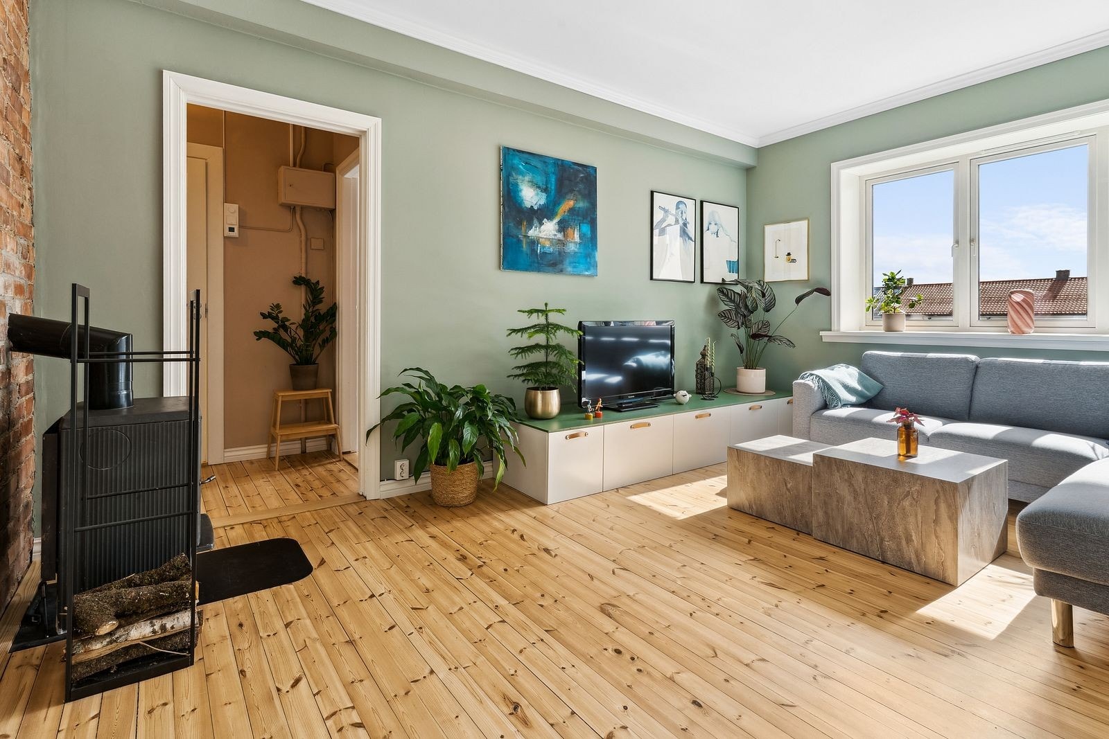 Stue med stor sofa, spisebord og TV-benk. God plass til både hverdag og sosiale sammenkomster Galleribilde