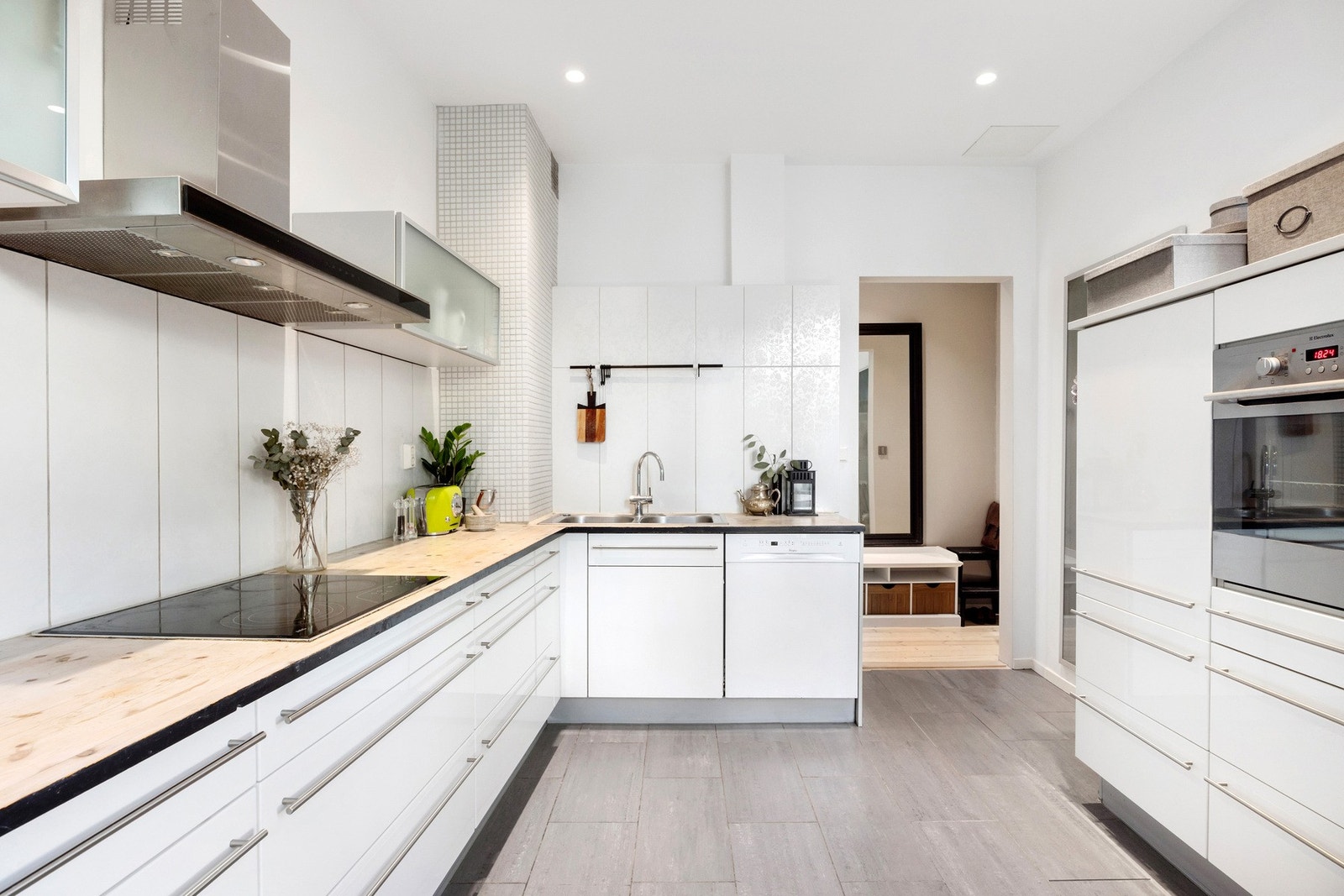 Moderne og funksjonelt kjøkken med integrerte hvitevarer, god skapplass og stilrene, hvite fronter Galleribilde