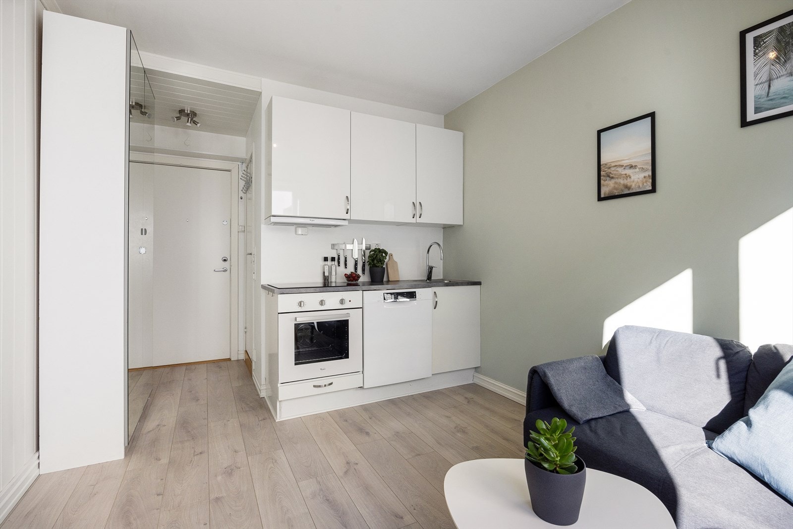 Kjøkkenet har glatte fronter, kullfiltervifte over stekesonen, kum med ettgreps blandebatteri og laminert benkeplate. Galleribilde