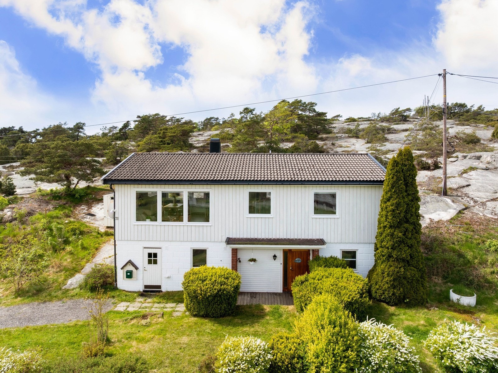 På tomtens østre side foran boligen er det i tidligere år anlagt hage med gressplen og prydbusker. Galleribilde