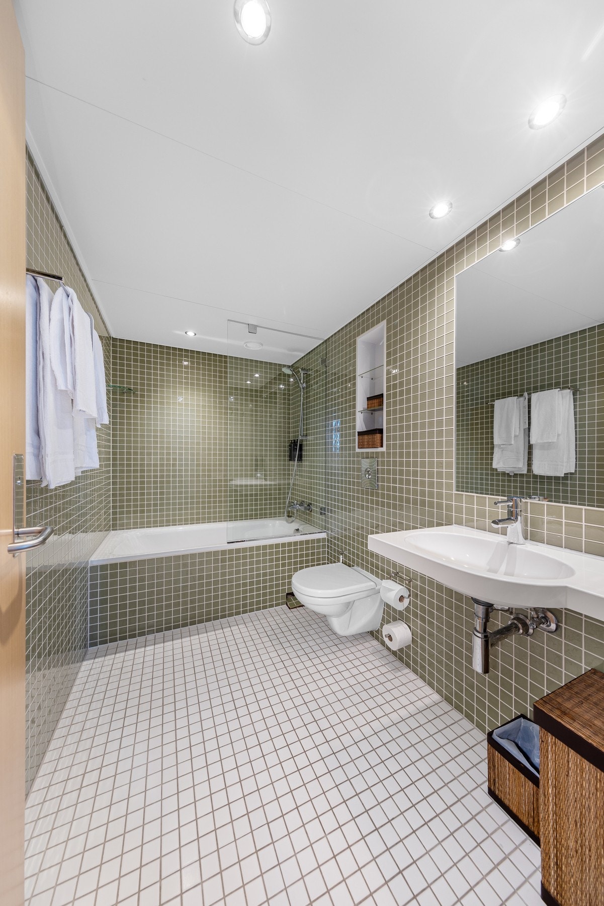 Hotellrommet har et flislagt bad med varmekabler, downlights, Grohe-innredning, vegghengt toalett og badekar. Galleribilde