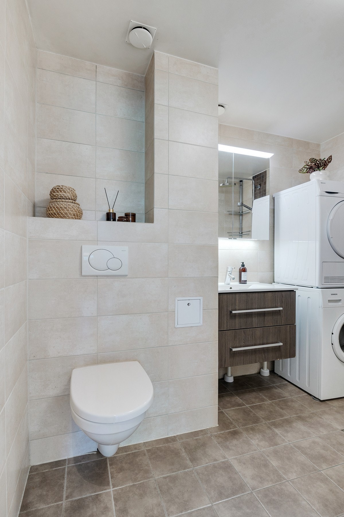 Baderomsinnredningen er bestående av servant med skuffeseksjon, speilskap med overlys, vegghengt klosett, dusjhjørne med forheng. Galleribilde