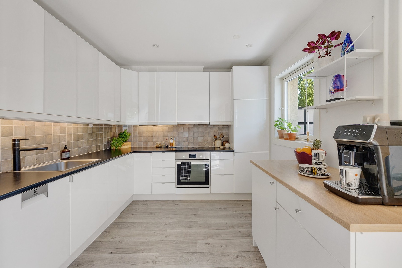 Pent og moderne kjøkken som har godt med skap- og benkeplass. Galleribilde