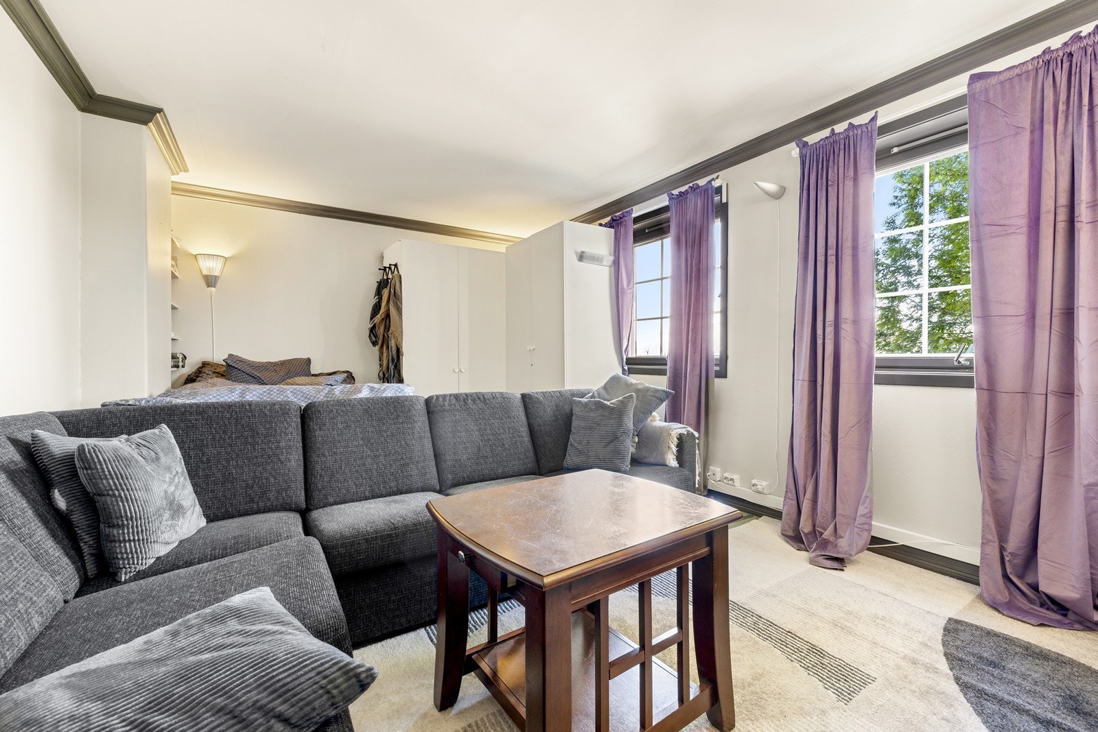 Lys stue med plass til både sofa og spisebord, samt seng og garderobeskap. Galleribilde