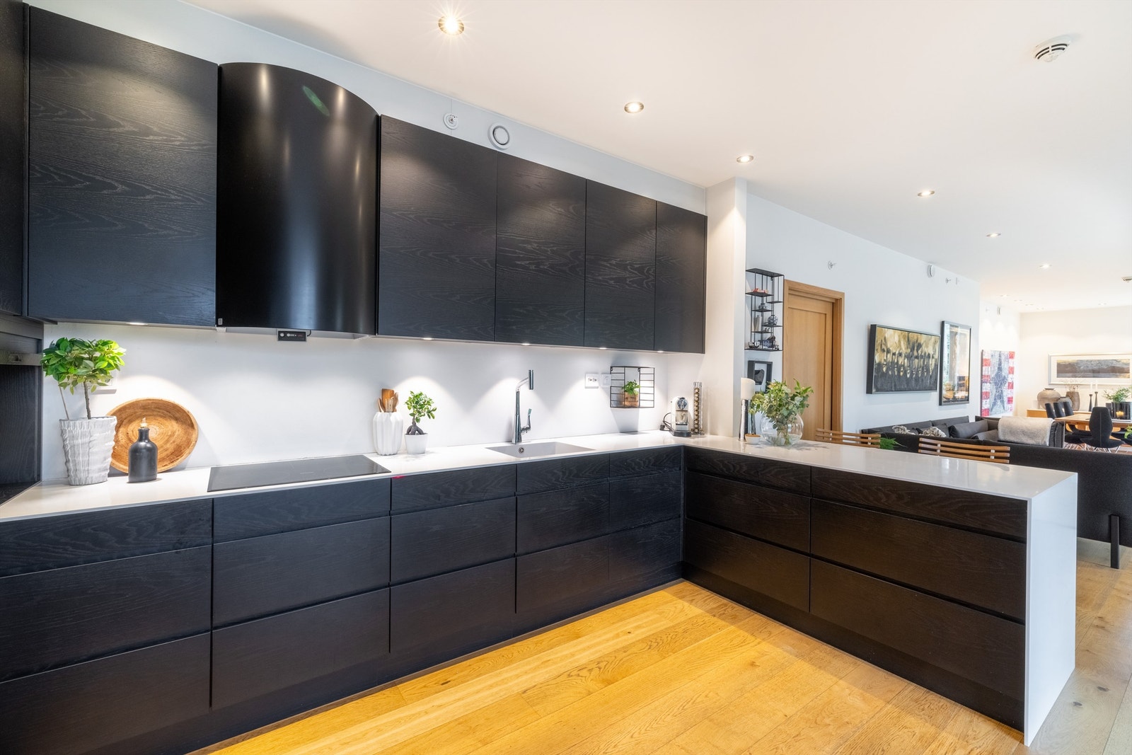 Nyere plassbygd kjøkkeninnredning fra Lesjaskog Møbler fra 2017 med mørke fronter og benkeplate i hvit Corian Galleribilde