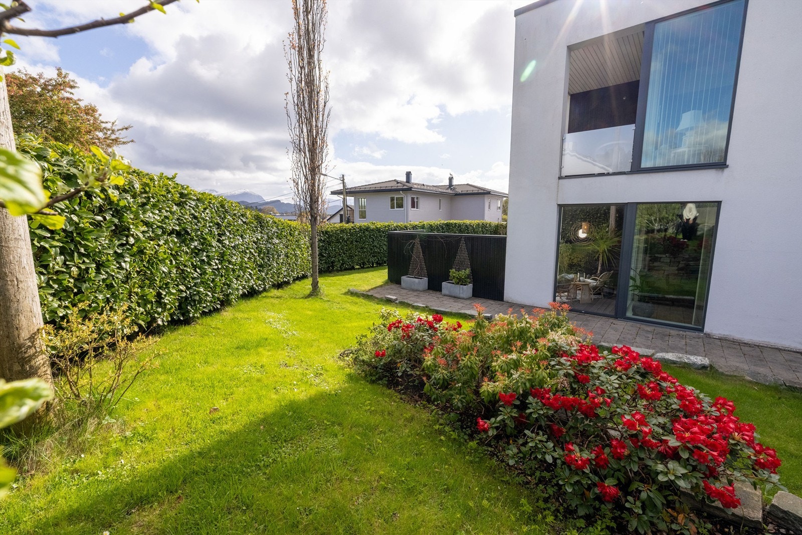 Pent opparbeidet hage og terrasse som tilhører leiligheten Galleribilde