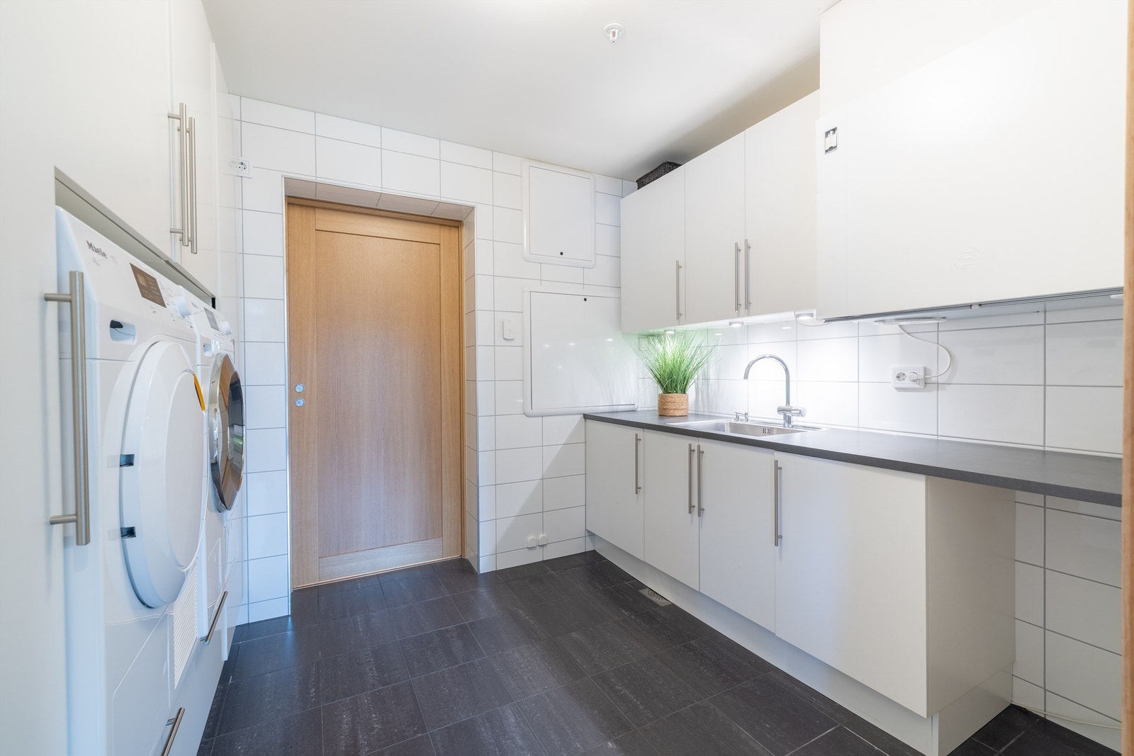 Stort og praktisk vaskerom med innredning Galleribilde