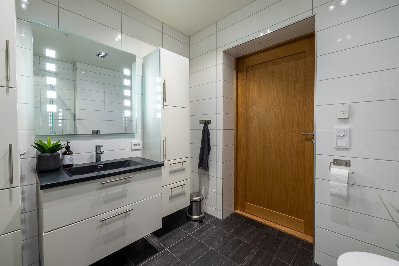 Hvit baderomsinnredning med nedfelt servant og ett-greps armatur på bad mot øst Galleribilde