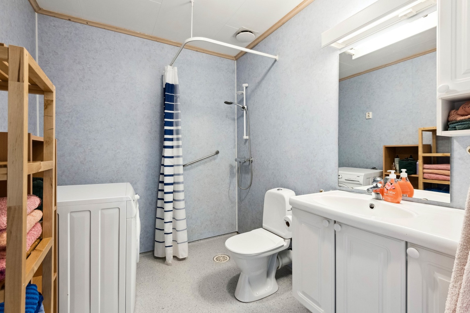 Badet er innredet med servant, gulvmontert wc, dusjhjørne med forheng samt opplegg for vaskemaskin. Galleribilde