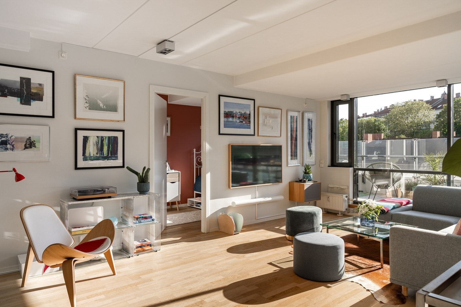 De store vindusflatene langs hele langveggen gir fantastisk lysinnslipp, utsyn mot byens tak og grønne tretopper, og skaper en behagelig atmosfære i rommet. Galleribilde